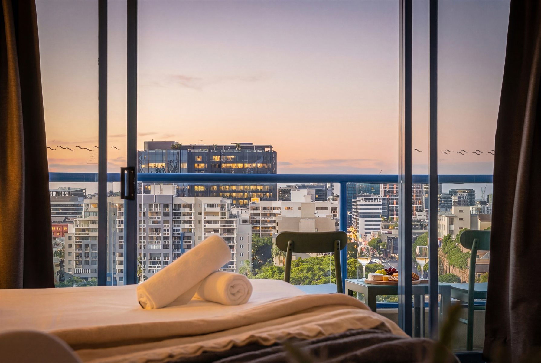 Prepared bed and city view at Mantra 1205 in Brisbane